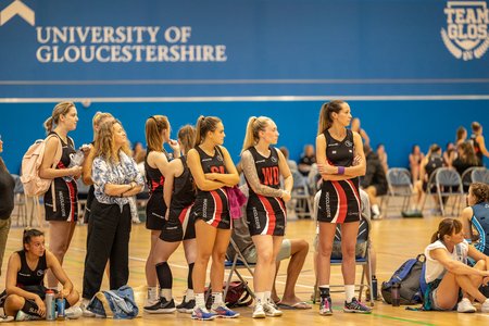 Hucclecote team watching from the side of the court